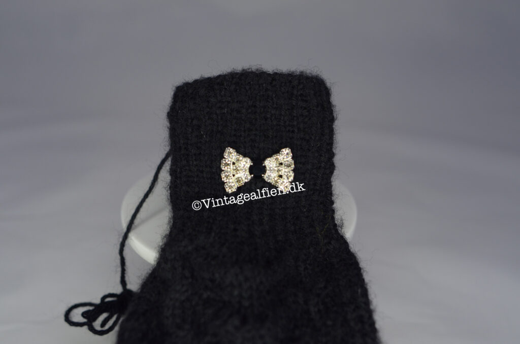 Sorte strikhandsker med påsat lille sløjfeknap med midte af sort sten 