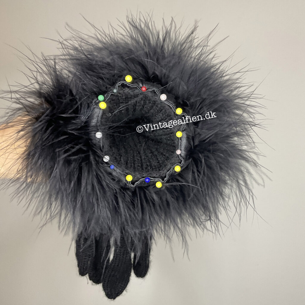 De sorte strikhandsker med med den pånålede strudsepels